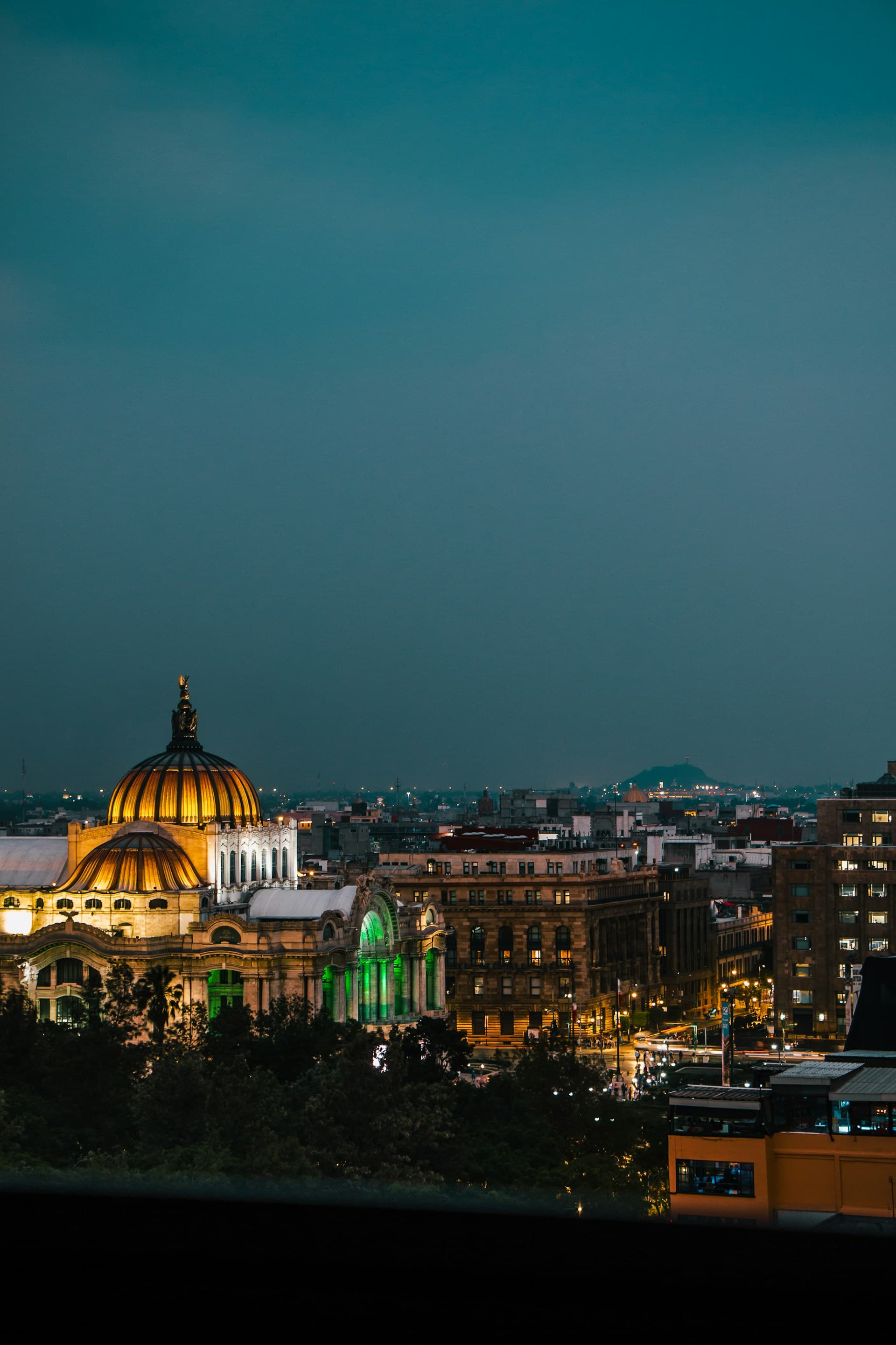 Mexico City rooftop night view with the Palacio de Bellas Artes and downtown skyscrapers illuminated