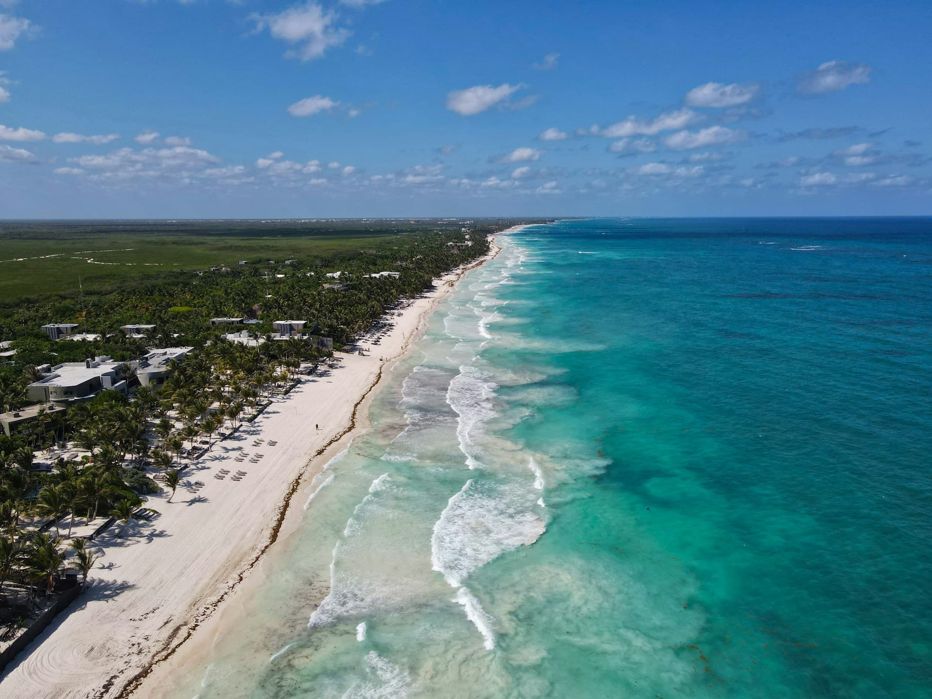 Aerial view of Playa del Carmen beach, turquoise Caribbean water, and the coastline curving south
