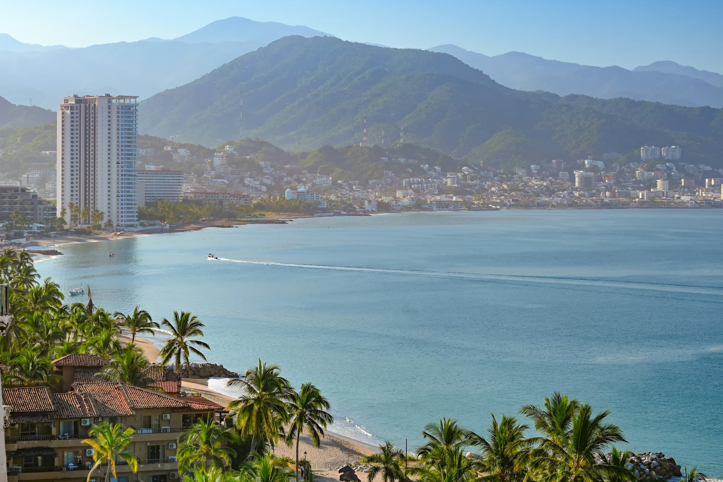 Puerto Vallarta beach in the foreground with the city and Sierra Madre rising behind it