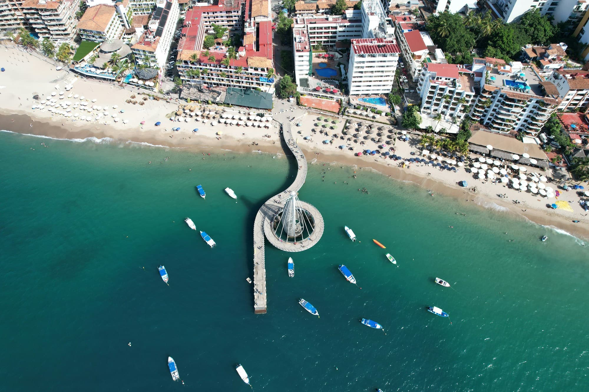 Aerial view of Playa de los Muertos beach and its iconic spiral pier in Puerto Vallarta's Zona Romántica